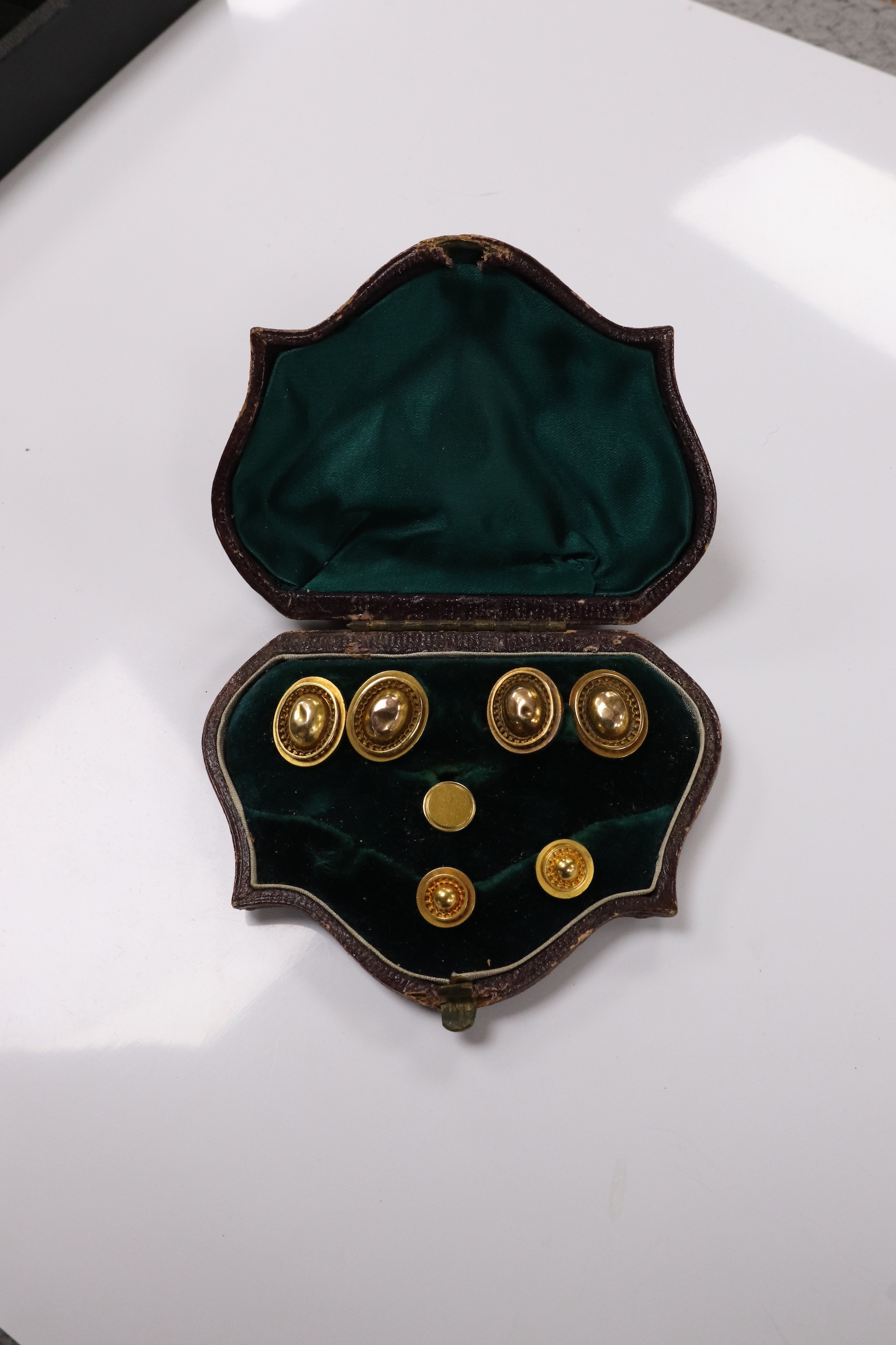 A pair of yellow metal oval cufflinks and three similar dress studs, one stamped 18, gross weight 10.8 grams. Condition - poor